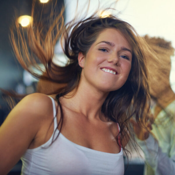 Young woman dancing to the music at a concert. This concert was created for the sole purpose of this photo shoot, featuring 300 models and 3 live bands. All people in this shoot are model released.